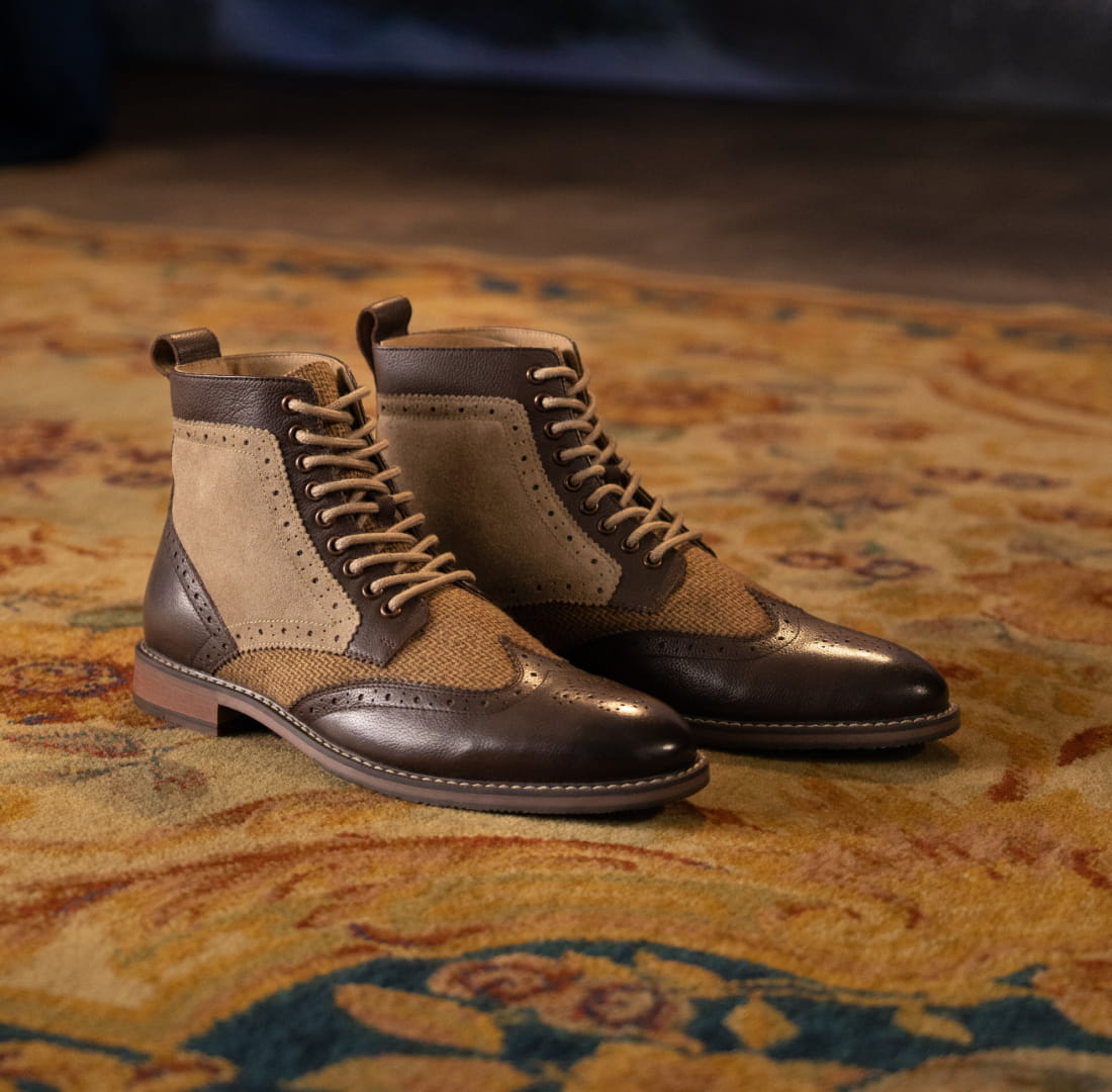 Shop Stacy Adam's Boot Category featuring the Finnegan Wingtip Lace Up Boot in Brown Tumbled on a patterned rug.