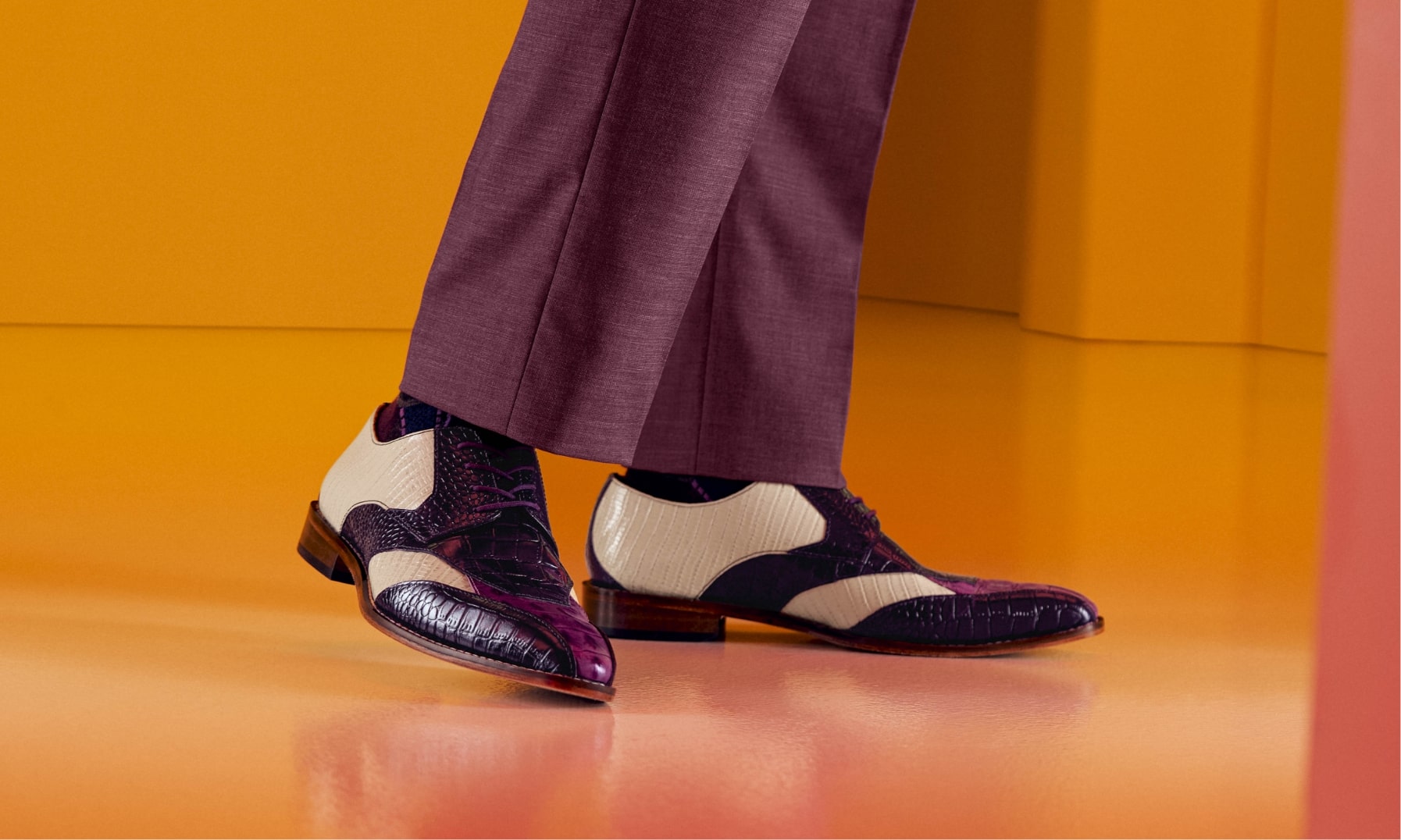 Click to shop Stacy Adams dress featuring the Tristano in purple on an orange floor.