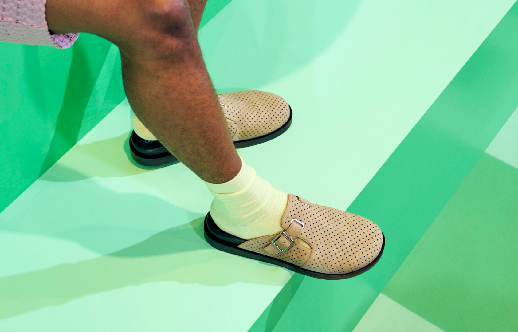 Image features the Montaine slip on in sand on a green background.