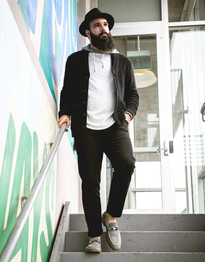 Image of social media influencer Anthony Mastracci walking down steps outside while wearing the Colbin Moc Toe Ornament Strap Slip On in Gray Suede. 