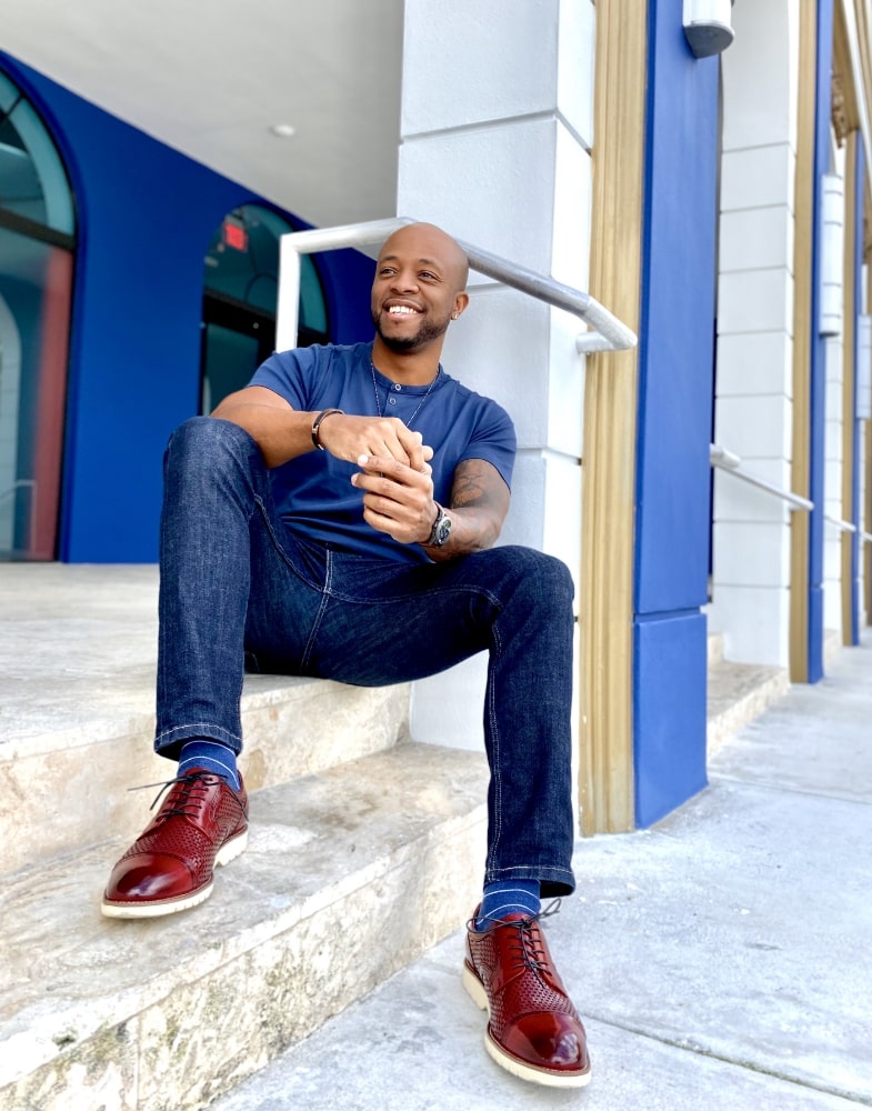 Image of social media influencer Kenny Daniels wearing the Ellery Cap Toe Oxford in Red outside in Miami, Florida.