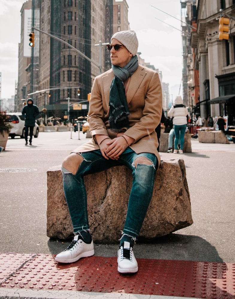 Image of social media influencer Uros Polajzer sitting on a rock outside in the Halden Cap Toe Elastic Lace Up in White.