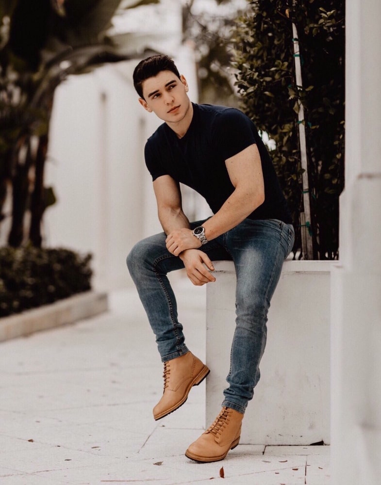 Image of social media influencer Ryan Kolton wearing the M2 Plain Toe Boot in Natural while sitting on a flower box.