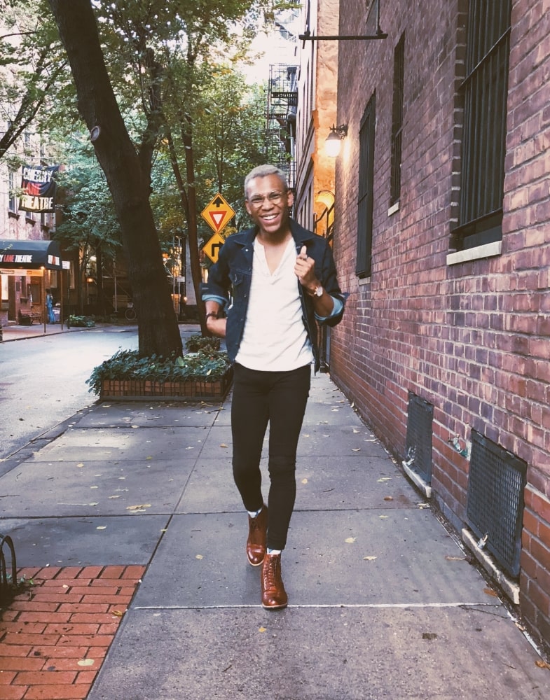 Image of social media influencer Steven Sharpe Jr. wearing the Madison Cap Toe Lace Boot in Cognac while walking along the city streets in New York.