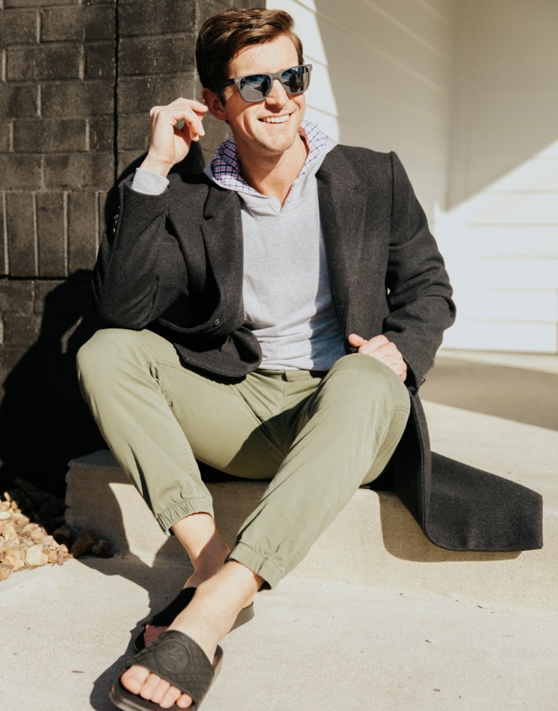 Image of social media influencer Cameron Hinkle sitting outside while wearing the Shuffle Slide Sandal in Black.