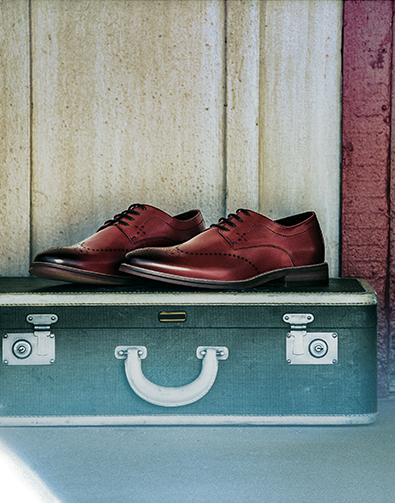 Image of a feature from the October 2017 issue of Esquire Magazine. The featured product is the Alaire Wingtip Oxford in Cranberry, rested on top of a suitcase.