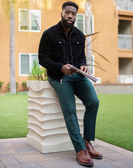 Image of social media influencer East Angles leaning up against a piller outside while wearing the Callan Wingtip Oxford in Cognac.