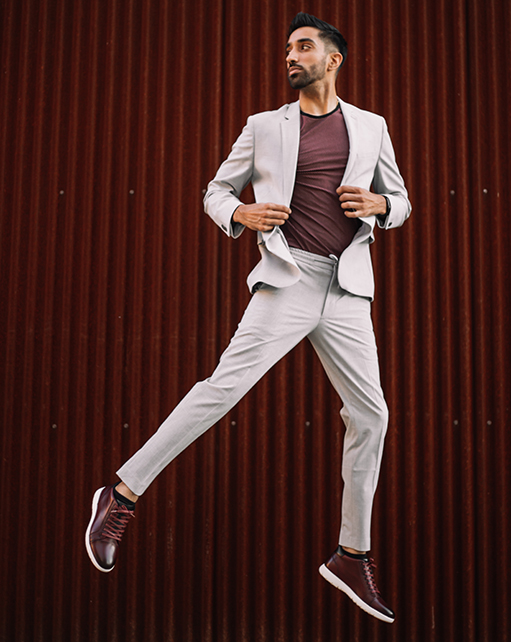 Image of social media influencer Gurneet Mangat jumping while wearing the Harlow Cap Toe Mid Lace Up in Burgundy Milled.