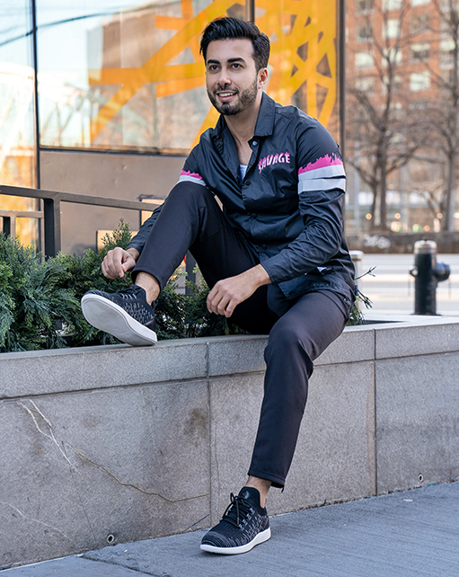 Image of social media influencer Mark Bay sitting on a ledge outside while wearing the Brio Knit Mid Lace Up in Black.