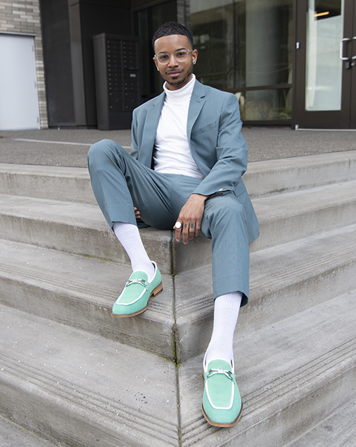 Image of social media influencer Christopher Chin sitting on steps outside while wearing the Colbin Moc Toe Ornament Strap Slip On in Green Aqua.